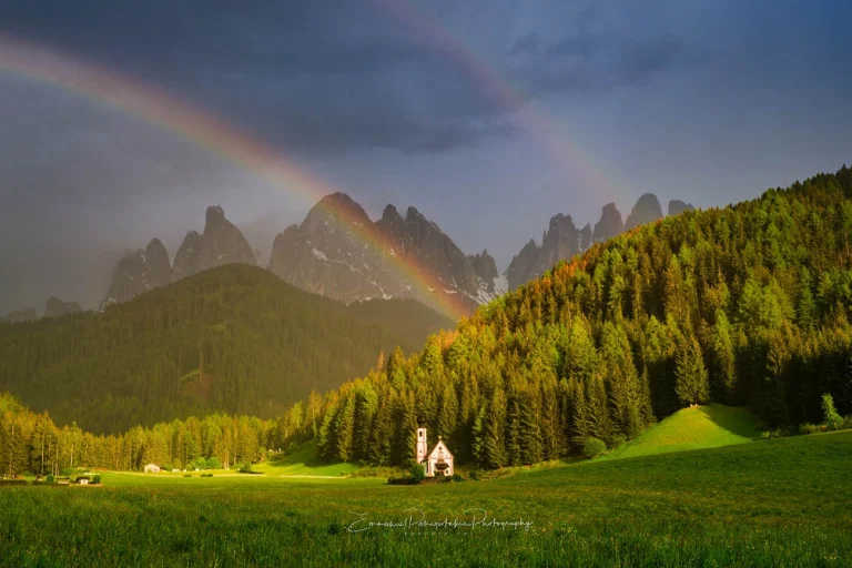 Timeless Image of a double rainbow over the Dolomites and St. Giovanni Church.